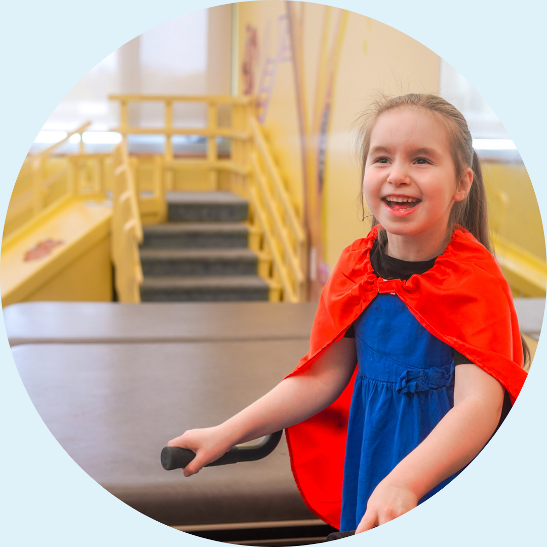 A young girl wearing a red cape