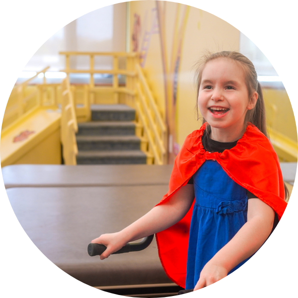 A young girl wearing a red cape